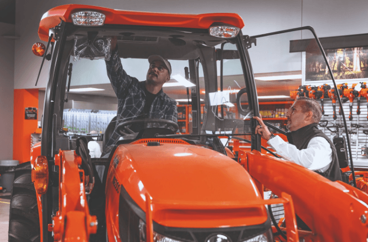 Man looking at a Kubota tractor