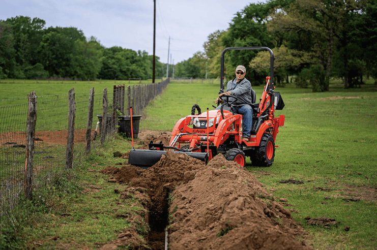 Man using tractor to back fill