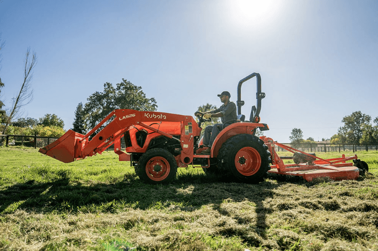 Man using land pride mower rear implement