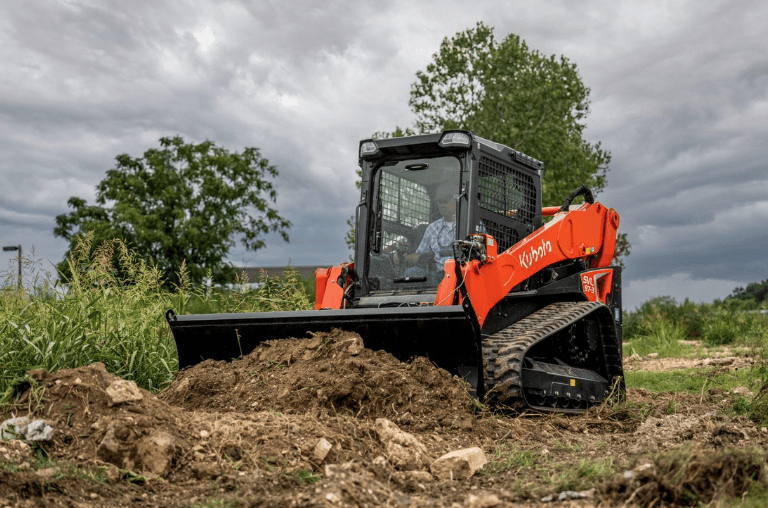 Shoving dirt with a bucket into a pile