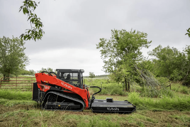 Track Loader using a rotary cutter to mow down over grown grass