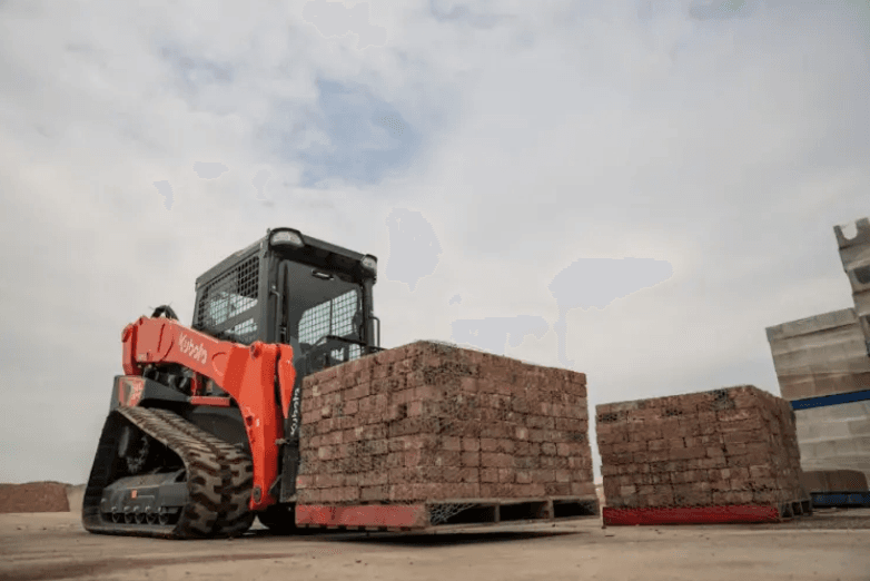 Track Loader moving pallet of bricks
