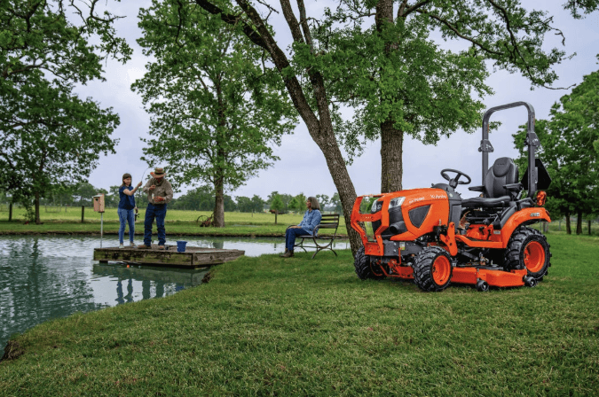 Sub-compact tractor parked alongside a pond