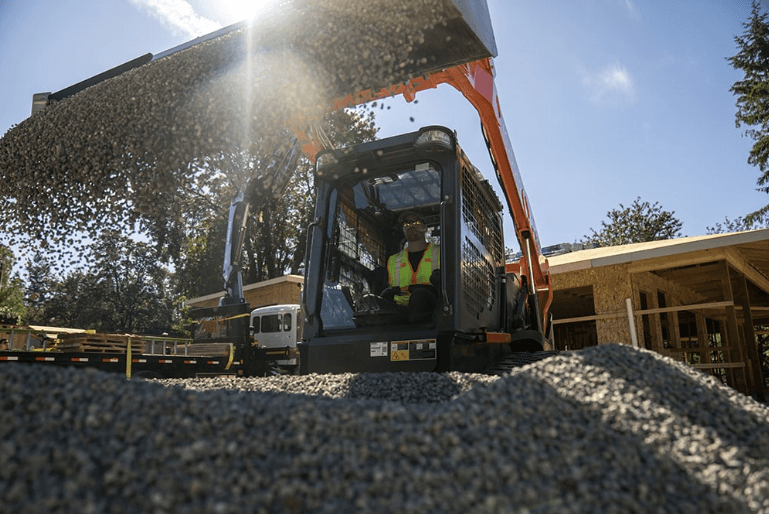 Close up shot of a loader dumping gravel