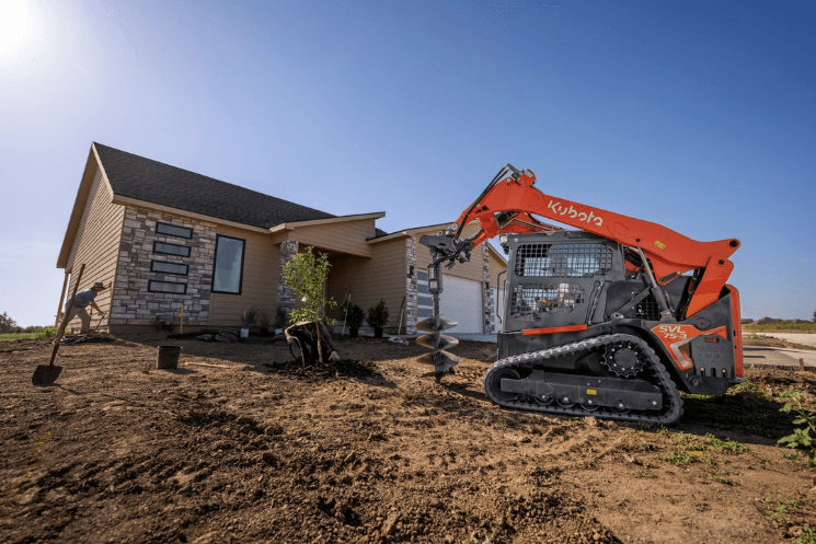 Track Loader using an auger to plant tree